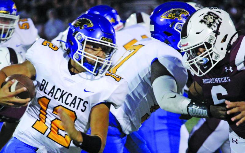 Sentinel photo/Mike Reddell Blackcat quarterback Joel Davalos (12) battles for yardage against Columbia defenders.