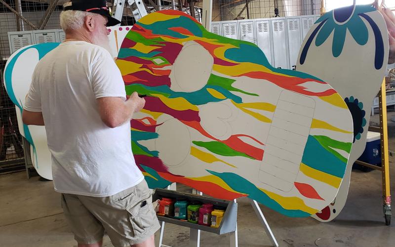 Sentinel photo/Jessica Shepard Local artist Rayleigh Conklin works on finishing up a groovy paint job on one of several large sugar skull displays for the "Day of the Dead" festival, Oct. 22. The festival is slated for noon to 10 p.m. Saturday, Nov. 6, at Le Tulle Park.