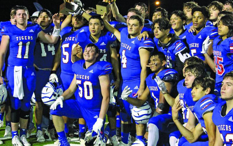 Sentinel photo/Mike Reddell Tidehaven Tigers celebrate after defeating the undefeated and 10th ranked 3A-2 team Odem Owls in the area playoff Saturday in Victoria. The players hoist the area and bi-district trophies they earned so far.