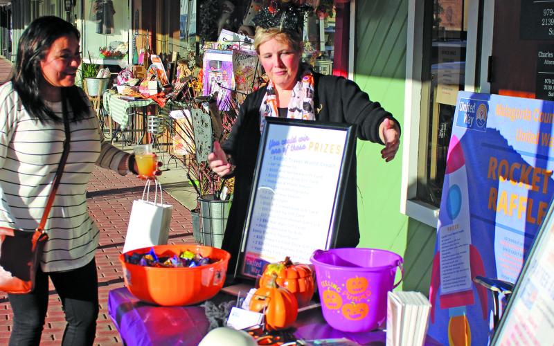 Sentinel photo/Jessica Shepard Matagorda County United Way Executive director Elizabeth Quillin sells Rocket Raffle tickets during the Bay City Main Street Program's first-ever "Witches Who Wine" shopping event, Thursday Oc. 28.