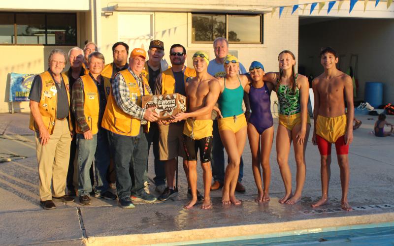 Sentinel photo/Jessica Shepard Bay City High School Aquacats collected and donated almost two dozen pairs of eyeglasses to the Bay City Lions Club members. The collection effort was led by swimmer Michael Vargas, center-right, who is handing the box of glasses to Bay City Lions Club President Steven Johnson, center-left.