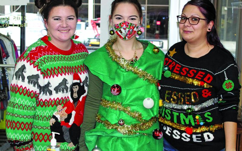 Sentinel photo/Jessica Shepard This trio of Burlap Sack employees is decked out for Bay City Main Street Program's "Ugly Sweater" event Thursday, Dec. 16. Pictured from the left are Bailey Phillips, Sophia Landry, and Jessica Lara.
