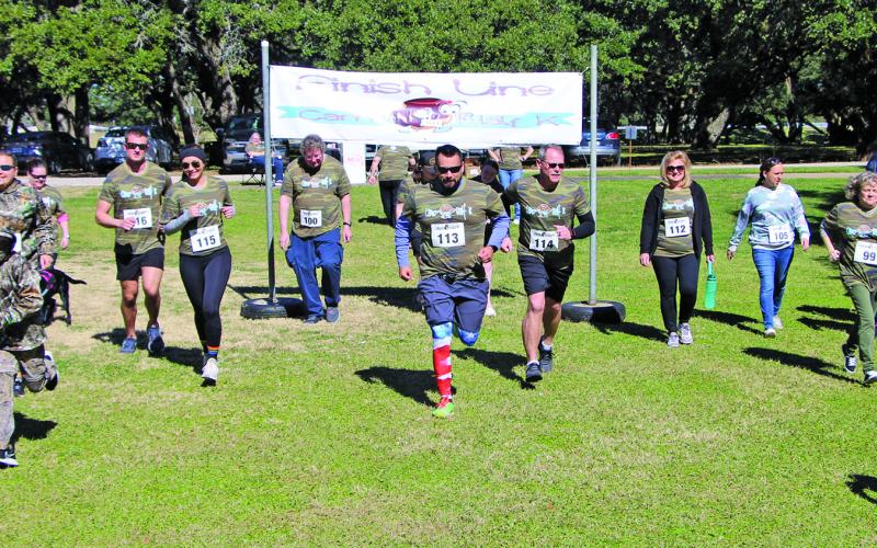 There were 18 participants in the Parks &amp; Recreation Department’s 2022 Camo Half K Saturday morning, Jan. 29, at LeTulle Park. Cale Crowley carried Haylee Hadash on his back after the race for her to receive the trophy for the slowest runner. Other trophies went to: Robert Reed - fastest overall and male; Nicole Sears – fastest female; Stephanie Reed - best Camo. Sentinel photo/Mike Reddell
