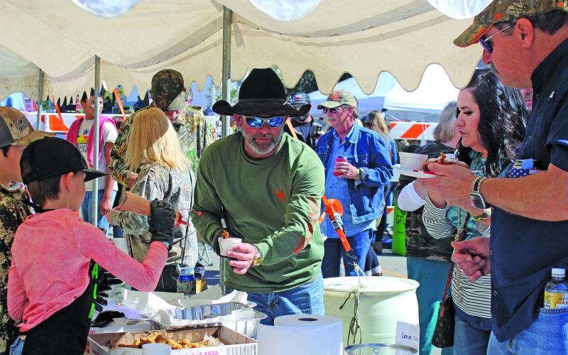 Sentinel photo/Jessica Shepard Serve Outdoors Matagorda Bay Chapter Member Clint Hewitt, center, hands out samples of fried alligator seasoned with Cajun spices and a dash of special sauce during the 6th Annual Camofest event Saturday, Jan. 29. The Serve Outdoors cooking teams also featured fried Oreos, fried Twinkies, daiquiris, and sausage.