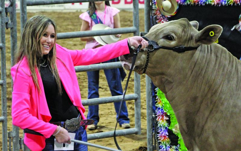 Sentinel photo/MaLinda Reddell Van Vleck FFA member Kenzie Brown is all smiles as she shows the Grand Champion steer at the 2022 Matagorda County Fair &amp; Livestock Association (MCFLA) Junior Livestock Auction she sold for $11,000 Saturday, March 5.
