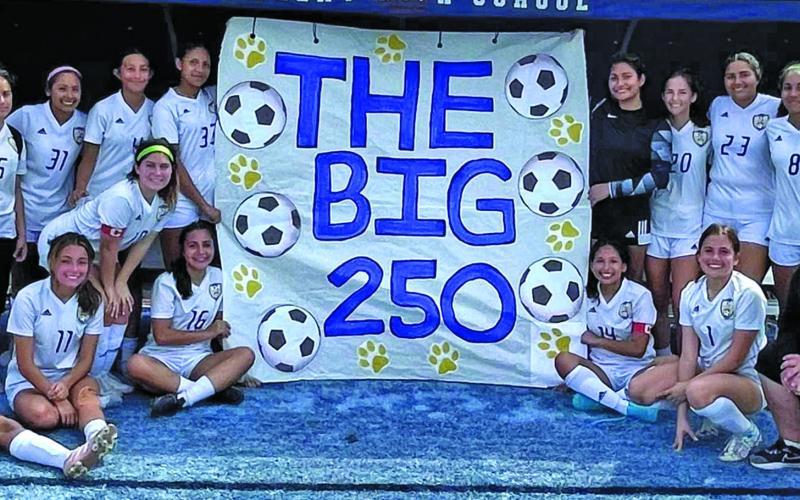 Contributed photo Ladycat Soccer members and Head Coach Darin Dobelgott show off banner proclaiming soccer program’s 250 win - since the girls started playing soccer - after defeating Sweeny there 4-0 Saturday, March 5, at Sweeny.