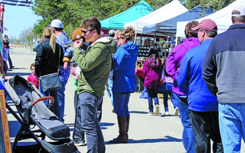 Sentinel photo/Jessica Shepard :Vendors draw a crowd as part of the annual "Surf &amp; Turf" festival, Saturday, March 12. The event attracted Spring Breakers and featured live entertainment, food, and raffle items