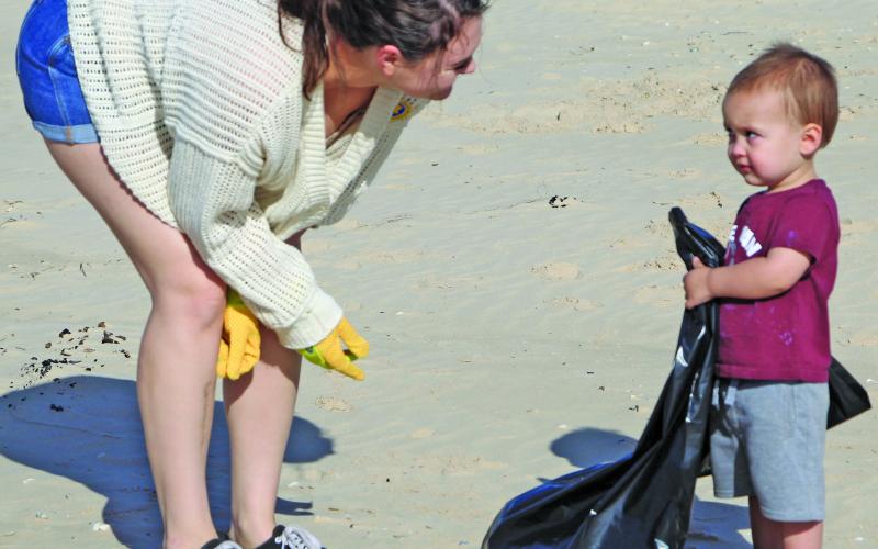 Sentinel photo/Mike Reddell A local Bay City mother teaching her son on what counts as trash as part of his cleanup experience.
