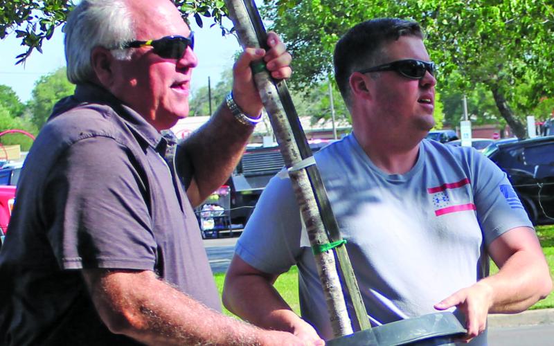 Sentinel photo/Jessica Shepard Bay City Chamber of Commerce and Agriculture President Mitch Thames, left, helps tree buyers at the chamber’s 58th Annual J.C. Lewis Live Oak Memorial Tree Sale April 22-23.