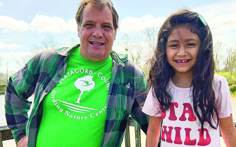 Contributed photo  MCBNC volunteer and board member Stephen Logan stands with “Name the Eaglet “contest winner Izabella Castillo. MCBNC volunteer and board member Diana Frankson stands with the second contest winner Harper Hill. Both photos were taken from on the lookout deck at the Matagorda County Birding Nature Center across from the bald eagle nest.