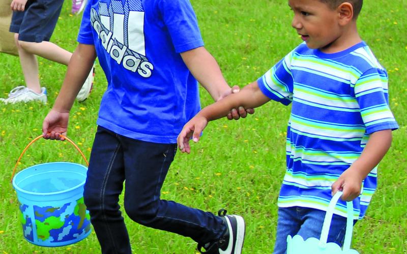 These youngsters team up to grab as many eggs as they can during the four-year-old portion of the hunt. Many of the younger age group divisions had adults helping children find the prize-winning eggs.  Sentinel photo/Jessica Shepard