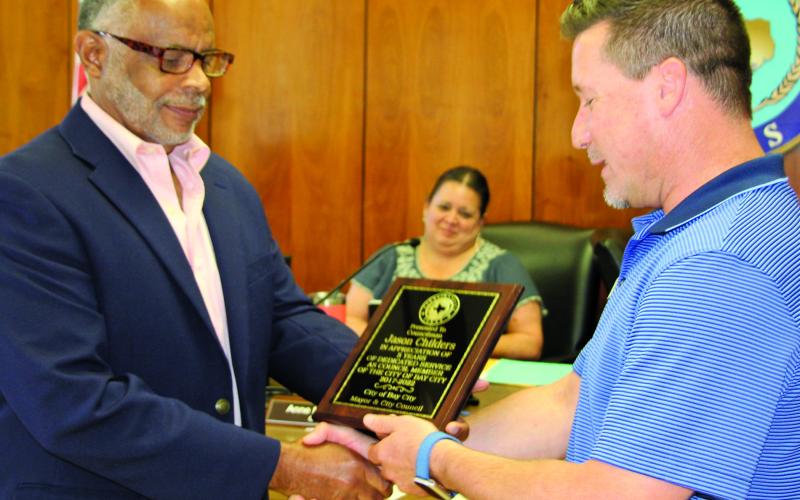 Sentinel photo/Mike Reddell Mayor Robert Nelson, left, presents outgoing City Councilman and Mayor Pro Tem Jason Childers a plaque expressing the city’s appreciation for Childers’ years of service.