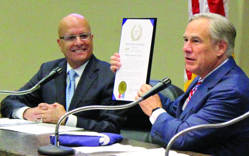Sentinel photo/Jessica Shepard HIF Global CEO Renato Pereira (left) looks on approvingly as Gov. Greg Abbott presents a state proclamation recognizing HIF’s selection of Matagorda County for the nation’s first eFuel plant and a Texas flag flown over the capitol.