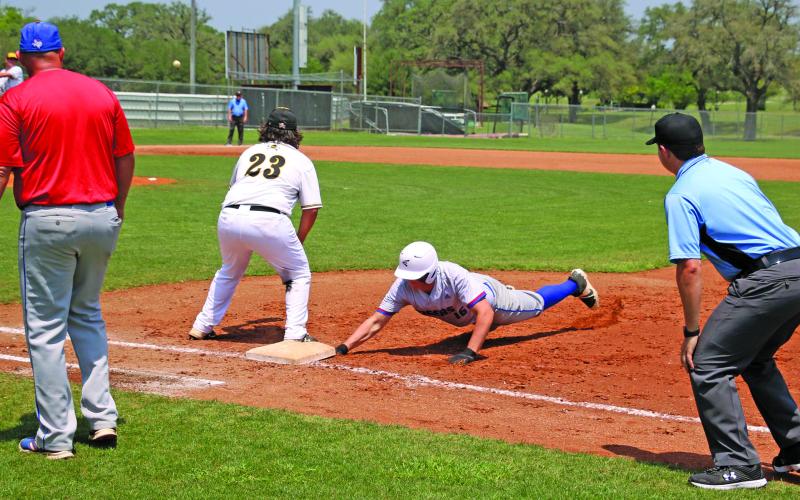 Photo by Ryan West Tidehaven runner beats the throw for a safe retirm at first