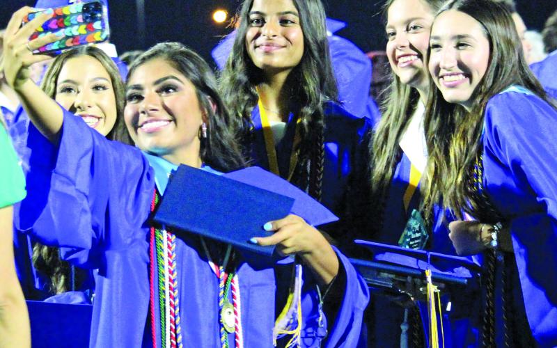 Sentinel photo/Jessica Shepard A handful of Bay City High School Class of 2022 graduates gather around for a little selfie action after their ceremony ended Friday, May 27