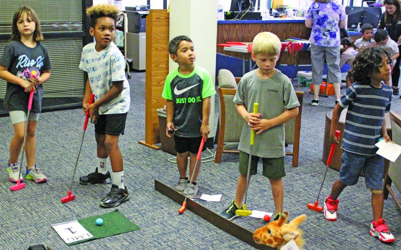 Sentinel photo/Jessica Shepard Children of all ages tried their luck with mini golf at the Bay City Public Library, Monday, June 13. The event was sponsored by the Friends of the Bay City Public Library and also featured food trucks and other games.