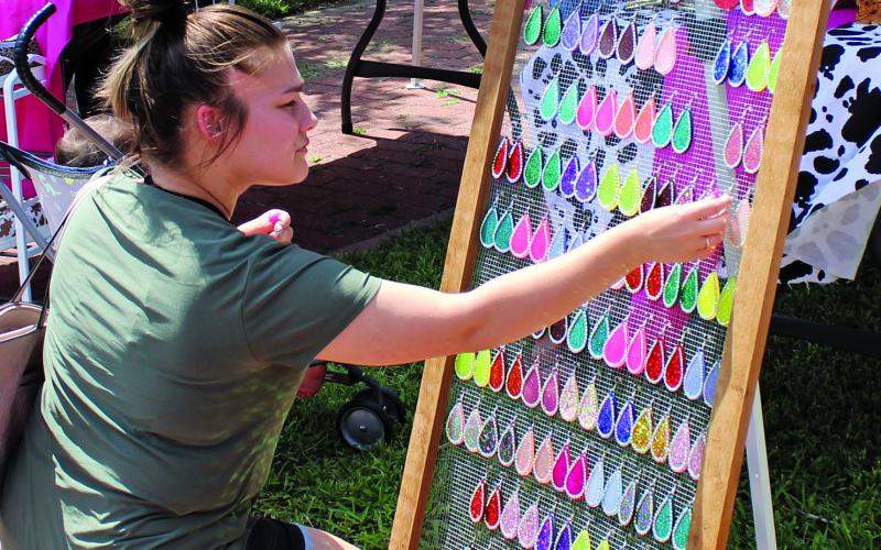 Sentinel photo/Jessica Shepard A weekend shopper at Matagorda Trade Days last Saturday checks out the multi-colored display of earrings.