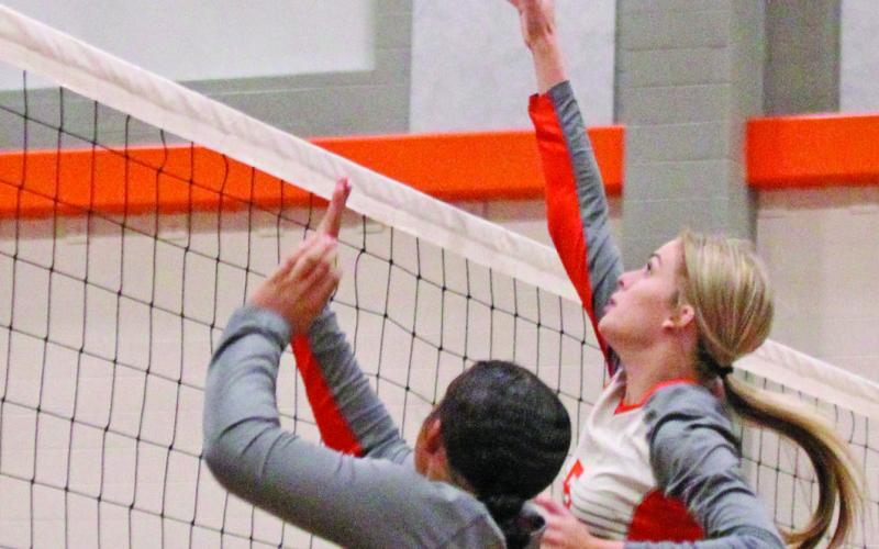 Van Vleck’s Ashlynn Winzenried (5) and Olivia Brittion (11) get the teamwork done during last week’s volleyball game against Bloomington.   Photo by  Anna Hernandez