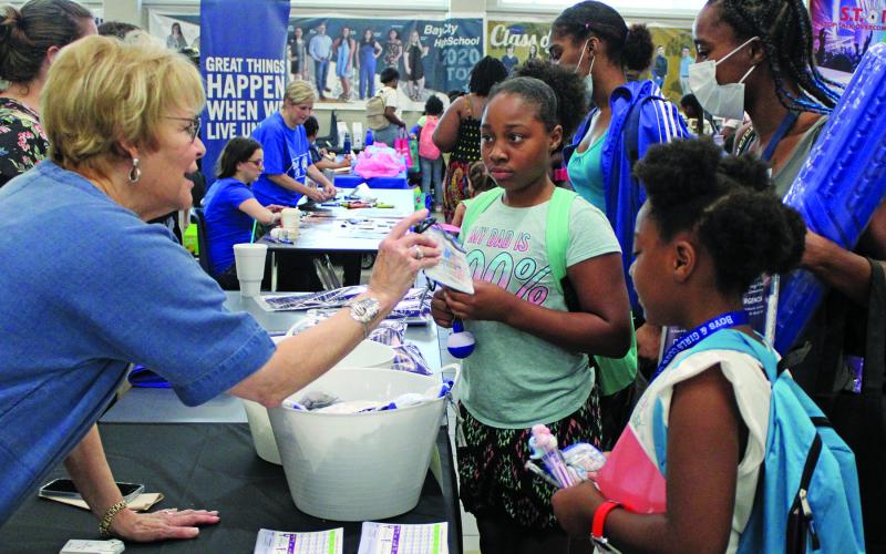 Sentinel Photo/Jessica Shepard Linda Allison, left, handed out treats for kids and information for Allison &amp; Thompson Insurance Services for parents during Bay City ISD's "Back to School Bash" Thursday, Aug. 11. Allison's booth was among over 40 at the event.