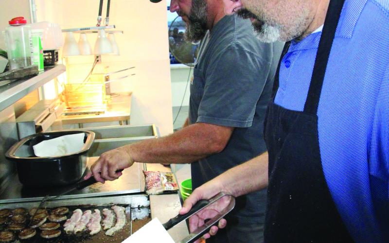 Tidehaven school trustee Stuart Lynn, left, was among several volunteers who pitched in for the Tidehaven senior breakfast last week.  Sentinel photo/ Mike Reddell