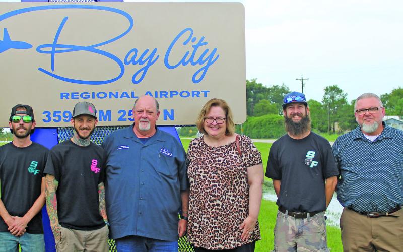 Sentinel Photo/Jessica Shepard Marking the recent completion of the new Bay City Regional Airport frontage sign on FM 2540 were, from left: Chase Meyers, Austin Gardiner, Stew Savage, all three with Savage Fab; Airport Manager James Mason; City Manager Shawna Burkhart; Savage Fab owner Chris Savage; Tourism Director Darve Smith; and City Council Member Blayne Finley.