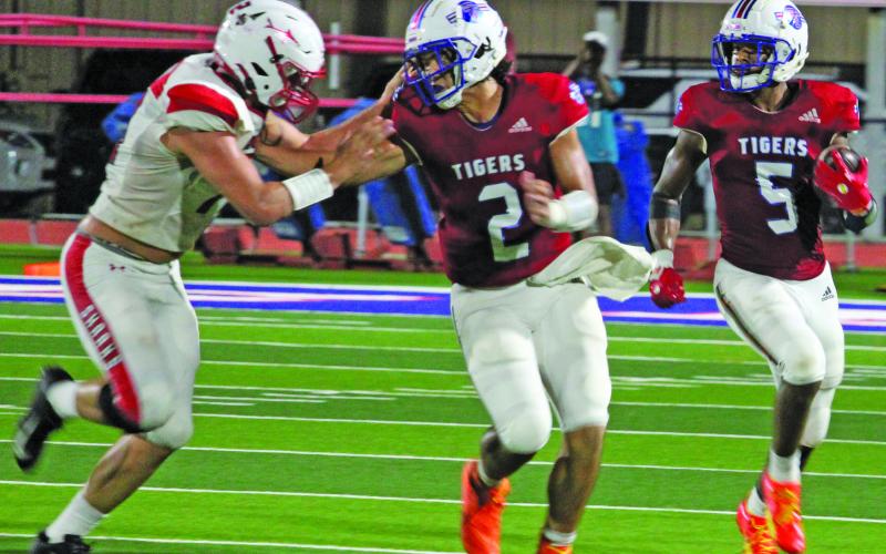 Sentinel Photo/Jessica Shepard Tidehaven quarterback Jachen Duran (2) blocks a Shark defender that gives Tiger running back Joseph Dodds (5) more room to run.