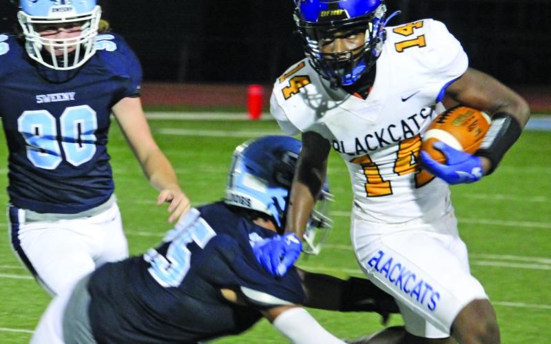 Sentinel Photo/Mike Reddell Blackcat running back Paris Fox (14) gets around two Sweeny defenders to pick up yards.