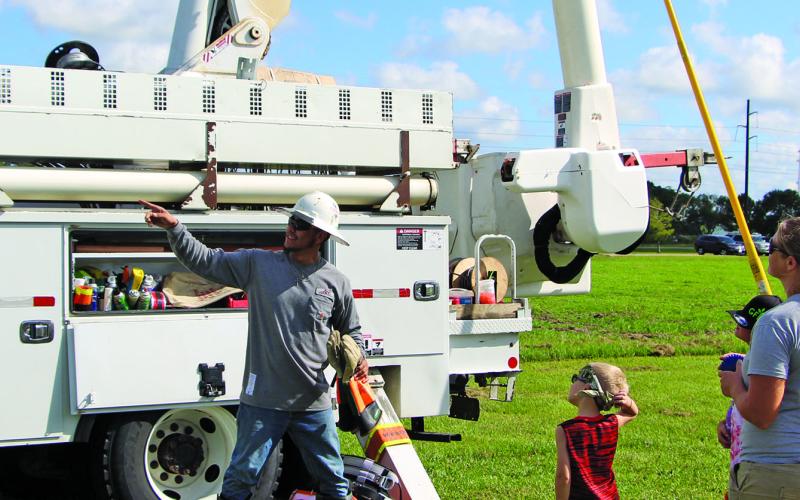 Sentinel photo/Mike Reddell A JEC employee explains how things work on a JEC utility bucket truck at the Touch a Truck event at Hardeman Park Saturday, Sept. 17. There was a good turnout at the Parks and Recreation Department event that also featured various equipment and work trucks.