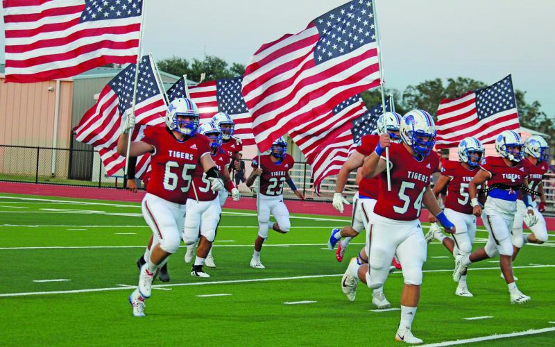 Sentinel photo/Jessica Shepard Tidehaven football players carry American flags as a 9/11 remembrance at last Friday’s Tidehaven-Palacios game. See related Tidehaven remembrance photo on Page 3.