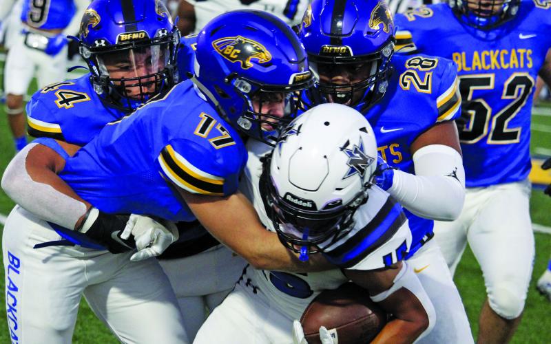 Sentinel Photo/Mike Reddell Blackcat senior linebacker Blake MacLennan (17) ties up a Navasota running back with the help of Elijah Suarez (44) and Karius Luster (28).