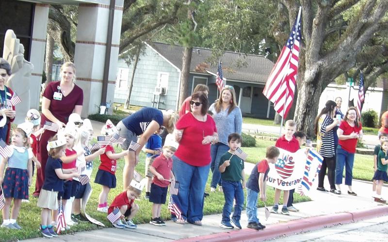 Photo courtesy of Holy Cross Catholic School Holy Cross Catholic School thanked all Veterans for their service on this Veteran's Day! Also, we would like to thank all those that helped make Veteran's Day Parade a success! We have our own veteran (Ms. Linda) that joined the parade with a walk thru instead of a drive thru. The students loved waving as she walked by, handing her a packet they put together for the veterans and hugging her!