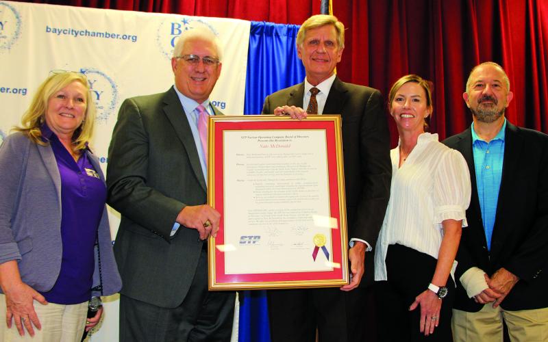 Sentinel Photo/Mike Reddell County Judge McDonald, center, is flanked by STP officials who include, from left: Kym Harshaw, chief nuclear officer; Tim Powell, STP president and chief executive officer; Savannah Cornelius, STP finance manager; and Al Capristo, executive vice president and chief administrative officer. They’re showing off an STP board resolution recognizing McDonald’s loyal service and partnership with STP on, among other things, emergency preparedness.