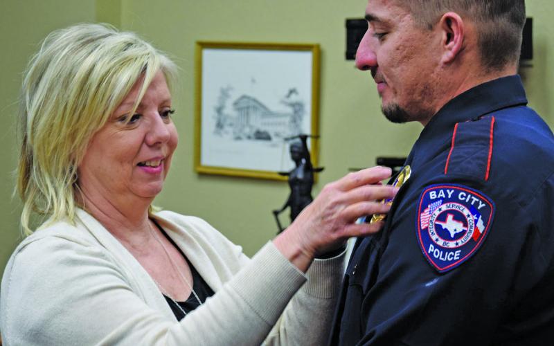 BCPD Photo Lt. Edward Guzman has his new gold lieutenant badge pinned on by his mother, Claudette Tupa, during his promotional ceremony Monday, Dec. 19.
