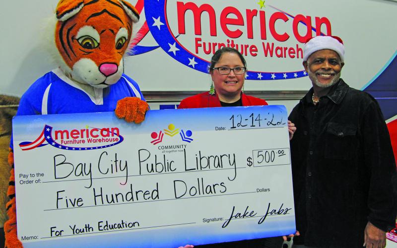 American Furniture Warehouse presented a $500 check to Bay City Public Library during the Bay City Regional Airport’s recent events around Santa’s airport visit. Shown are, from left: The Warehouse mascot, Lbrary Director Samantha Denbow and Bay City Mayor Robert Nelson. Sentinel Photo/Mike Reddell