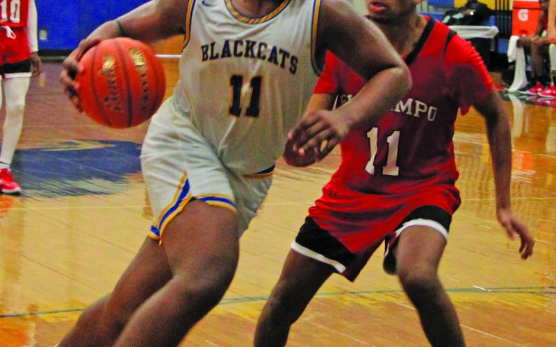 Sentinel Photo/Mike Reddell Blackcat forward Carlon Jones (11) drives against an El Campo defender at the Bay City Basketball Tournament last week.