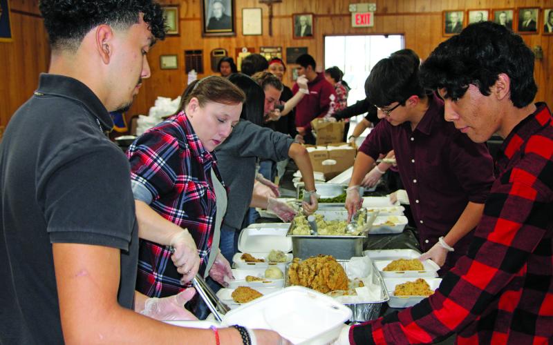 Sentinel Photo/Mike Reddell A team of volunteers helps prepare chicken fried steak dinners for the Crisis Center fundraiser at the Knights of Columbus Hall Friday, Jan. 20..