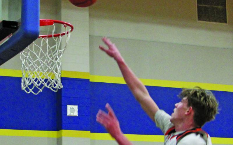 Sentinel Photo/Mike Reddell Van Vleck sophomore Micah Burks (21) scores on Calhoun at the Bay City Basketball Tournament last week.