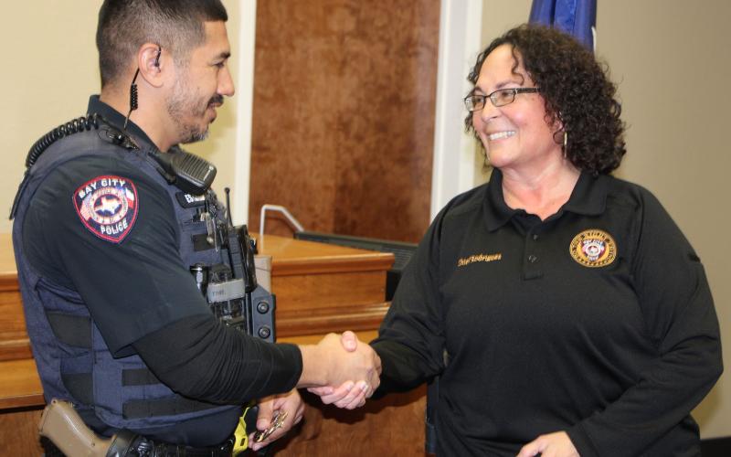 Sentinel Photo/Mike Reddell Newly promoted Corporal Jerome Estrada shakes hands with Police Chief Christella Rodriguez at a promotion ceremony last week.