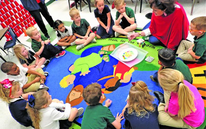 Holy Cross photo At Holy Cross Catholic School, Mrs. Allison offers her PreK–4 students all kinds of STEM activities that keep these little ones busy and teach them the basics of STEM that they'll need to succeed later in life. Her students look mesmerized as they experience the STEM project, "Color-Changing Milk Experi ment." Look how engaged they are as they hang on her every word.