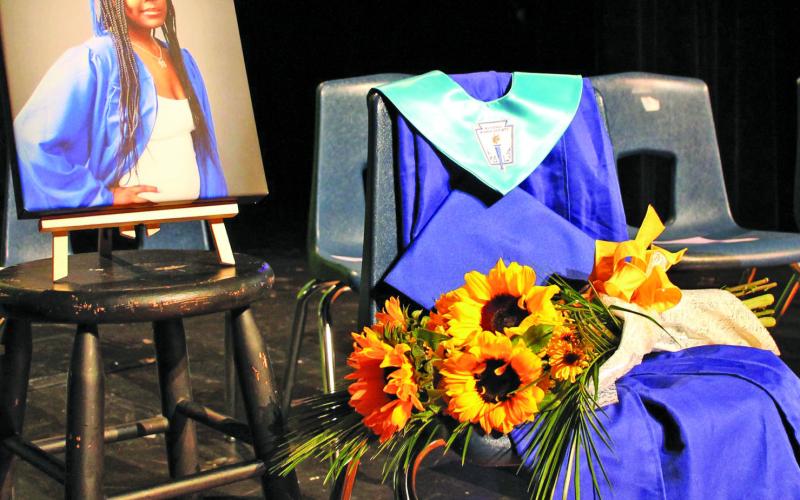 Sentinel Photo/Jessica Shepard Taryn Harris' graduation gown was on display alongside her graduation photo during a special graduation ceremony Monday, Feb. 20. Harris' diploma was presented to her family on her behalf.