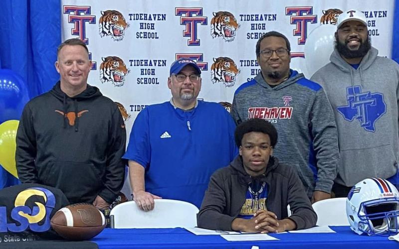 Tidehaven standout receiver Ti’Shaun Davis, seated, signed a commitment to play football with Angelo State at a recent signing ceremony. Standing with Davis are, from left, Tidehaven coaches Bill Russell, David Lucio, Darren Johnson and Melvin White. Contributed photo