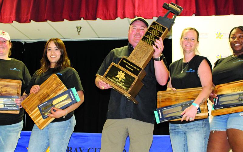 Sentinel Photo/Jessica Shepard The 13th Annual Great Steak Cook-Off raised over $85,000 Saturday, March 25. This year’s overall “Best Steak” award was given to Matagorda Regional Medical Center’s “Blue Line Cookers” with team members Jaquala Moore, Diane Wulf, Tammy Sanderson, and Maria Ortiz. MRMC CEO Warren Robicheaux, center, proudly holds the team's trophy to show off to the audience.