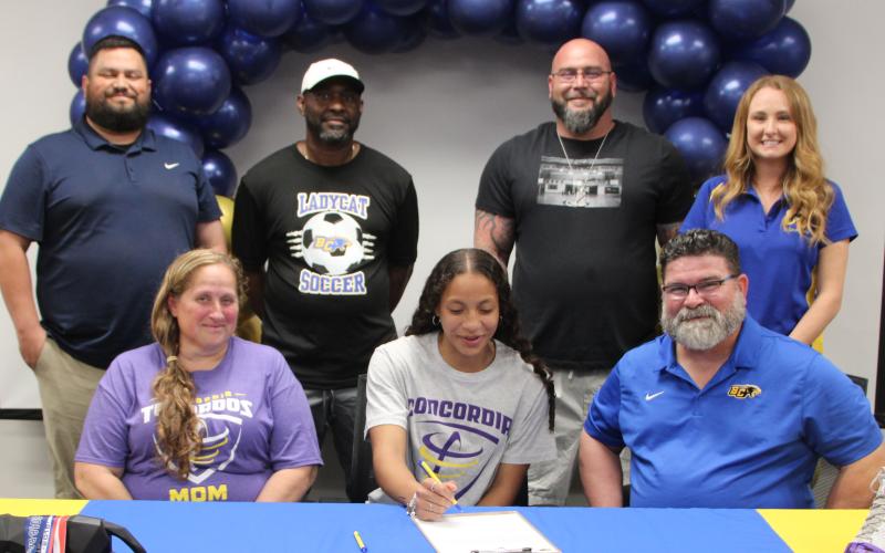 Sentinel Photo/Mike Reddell Bay City Lady Cat Ella Mata-Perez, center, signed with the Concordia University soccer team at BCHS ceremonies last week. Shown with Mata-Perez on front row is her mom, Vickie Perez, and her Soccer Coach Darin Dabelgott. In the back are, from left: Recreation Coach 6th grade through current Joe Villalovos; Conditioning Coach Squeaky Brinkley, Assistant Coach Will Cook, and High School Assistant Coach Tara Castro.