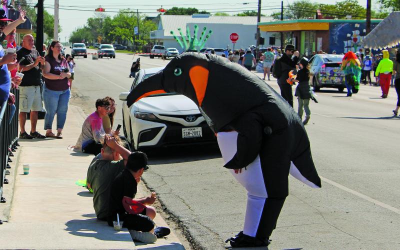 Participants in the 10th Annual Birdfest Parade in downtown Palacios Saturday, March 25, often visited with those lining the streets. This penguin - one of a pair in the parade - stops and talks with younger onlookers.  Sentinel Photo/ Mike Reddell