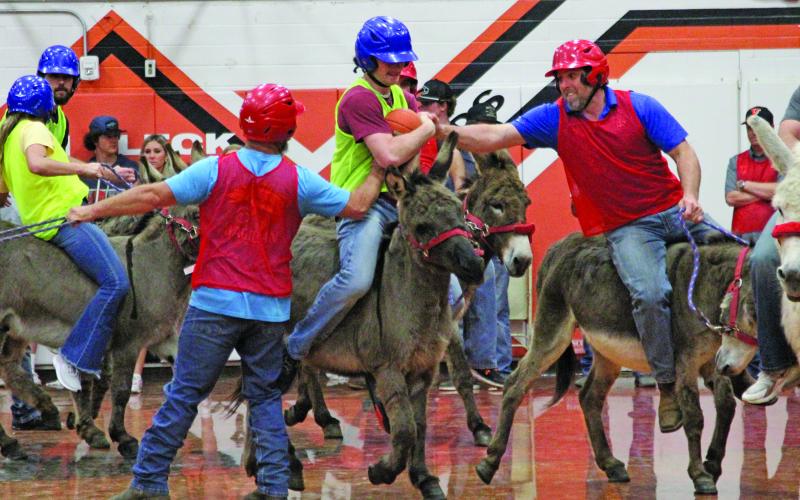 Anna Hernandez photo Van Vleck High School senior Carter McKnight tries his best to hold on to the ball when he is attacked by the Van Vleck Community Team during the recent Donkey Basketball game at VVHS.