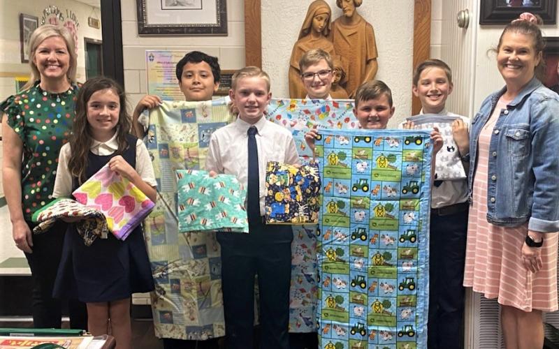 Holy Cross photo Jenifer Bossley's 5th graders, with the help of Mita Bossley, sewed baby blankets for the Women's Pregnancy Center. Then the Holy Cross Catholic School students presented the blankets to Laura Wendtland.
