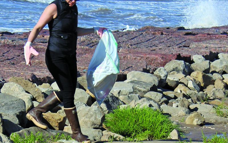 Sentinel Photo/Jessica Shepard Gusty winds and an incoming high tide weren't enough to stop this volunteer from cleaning up trash at Sargent beach Saturday, April 22. The annual "Texas General Land Office Adopt-A-Beach" cleanup featured teams of volunteers at beaches up and down the coast.