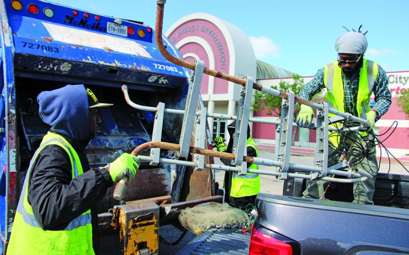 Sentinel Photo/Mike Reddell GFL employees wrestle with getting a discarded ladder into the trash compactor at the City of Bay City’s annual “Spring Cleanup” Saturday, April 29, at the WCJC parking lot.