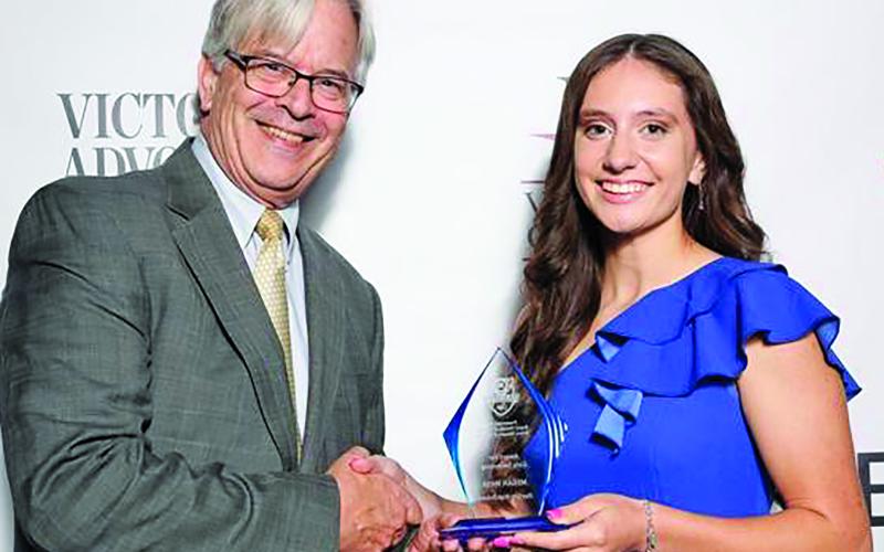 Courtesy photo Bay City swimmer Megan Moya was recognized as the area's Outstanding Girl Swimmer at the recent 5th Annual Varsity Cup awards ceremony in Victoria. She is shown with Victoria Advocated General Manager George Coleman. She was the Heart &amp; Desire Award winner in 2022 and the Girl Swimmer in 2023.