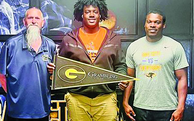 Courtesy photo Blackcat senior Zomaryon Bryan received a scholarship to play football at Grambling State University. Bryan, center, is flanked by Offensive Line Coach Ron Arneson, left, and Head Football Coach Robert Jones.